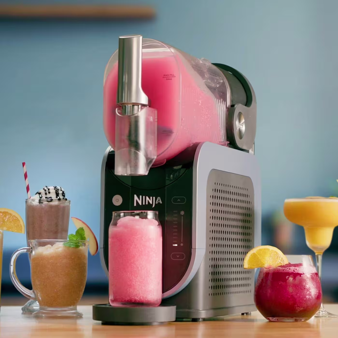 Ninja SLUSHi machine surrounded by colourful frozen drinks